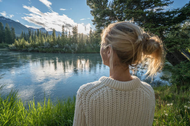 istock Blond girl watching sunrise from river bank 841646418