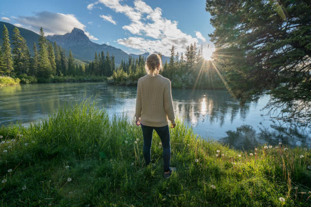 istock Blond girl watching sunrise from river bank 841646772
