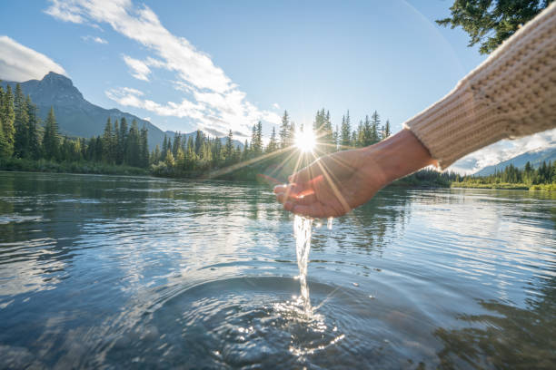 istock Human hand cupped to catch fresh water from mountain river 841647208