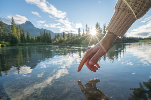 istock Finger touches surface of mountain river 841649622