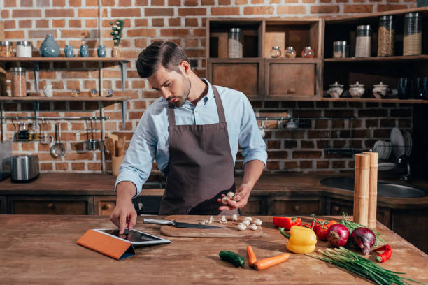 istock handsome young man looking for recipe in tablet 841649636