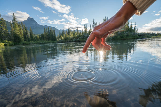 istock Finger touches surface of mountain river 841649756