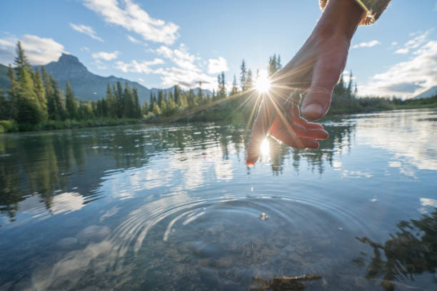 istock Finger touches surface of mountain river 841649760