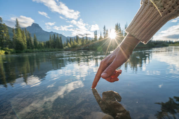 istock Finger touches surface of mountain river 841649852