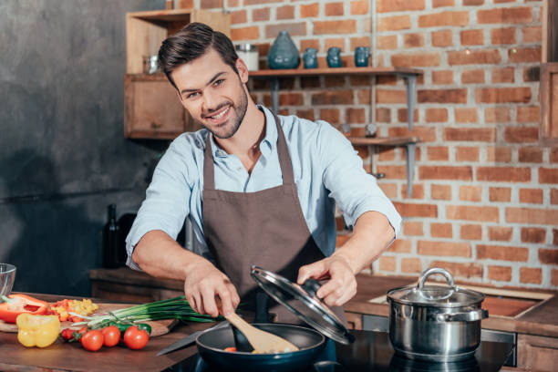 istock happy handsome man with apron cooking 841653084
