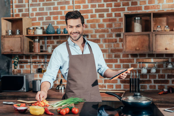 istock happy young man cooking with tablet 841653426