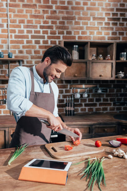 istock happy young man cooking with tablet 841653520
