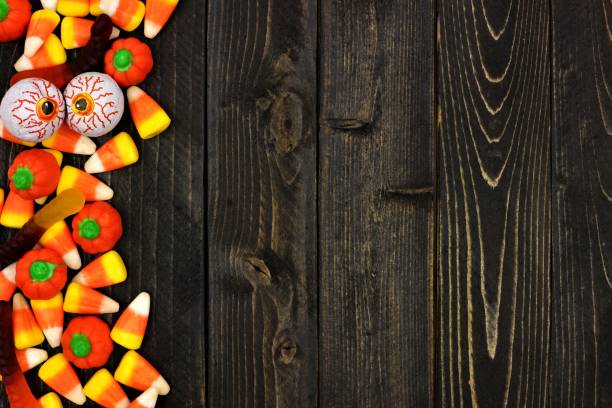 istock Halloween candy side border over dark wood 841654406