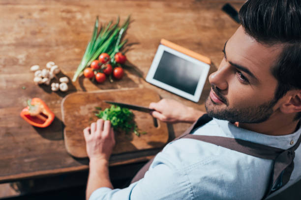 istock high angle view of handsome young man cooking with tablet 841656638