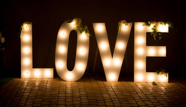 the inscription is love. glowing large letters. wedding decorations. - single word love wood typescript imagens e fotografias de stock