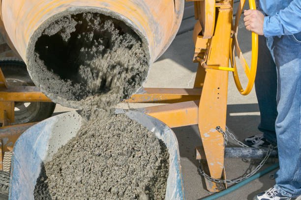 istock Worker pouring wet cement into wheelbarrow 841664150