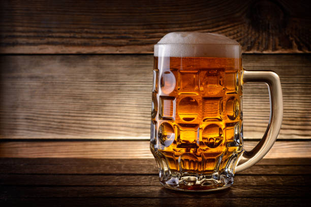 istock Mug of beer on rustic wooden background with copy space. 841664314