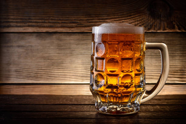 istock Mug of beer on rustic wooden background with copy space. 841664352