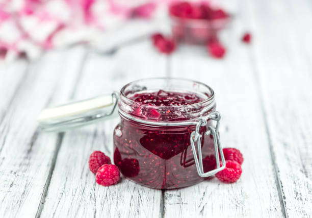 Fresh made Raspberry Jam on a rustic background Homemade Raspberry Jam on an wooden table as detailed close-up shot; selective focus raspberry jam stock pictures, royalty-free photos & images