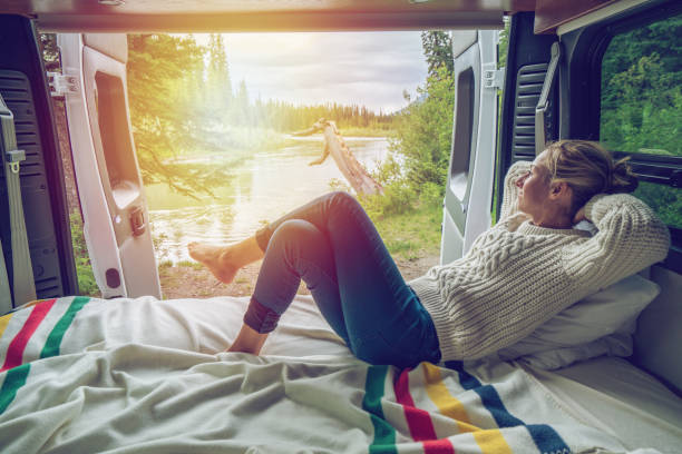 Young woman having a stunning view out of the back of her Camping Van Young woman having a stunning view out of the back of her Camping Van canada trip stock pictures, royalty-free photos & images