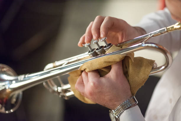 musica, jazz, concetto artistico. c'è lo strumento jazz più popolare, tromba, in vecchie mani curate di un giocatore professionista maschile, ha un orologio da polso argentato semplice ma lucido sulla mano sinistra - jazz ballet foto e immagini stock