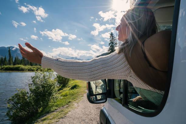 istock Young woman stretches arm out van window 841680722