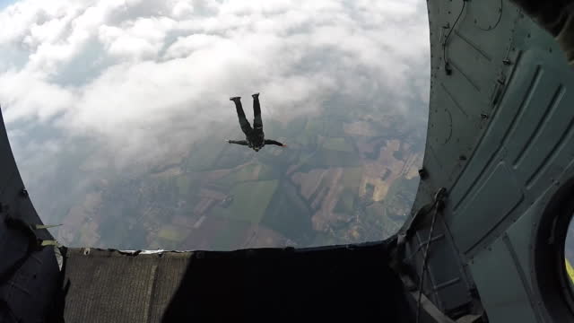 Skydiver jumping out of rear of airplane