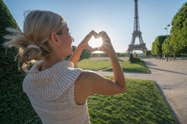 istock Blond girl making heart shape frame to Paris 841684182