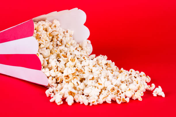 istock Spilled box of popcorn on red background 841689116