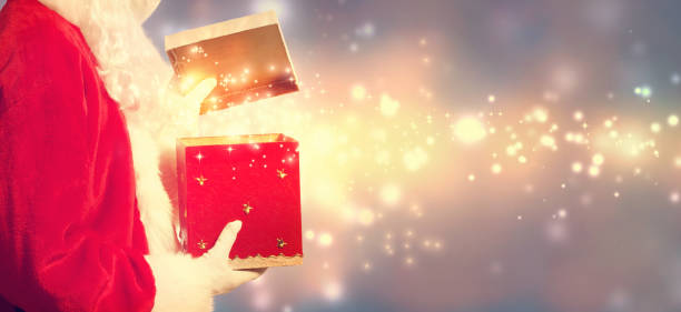 istock Santa Claus opening a red Christmas present 841742002