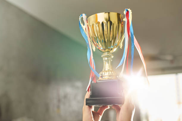 istock Young athlete holding up a gold trophy cup with space ready for your trophy design. 841764698