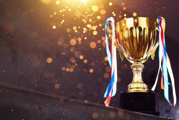 istock Low key golden trophy on the blur gray background with abstract shiny lights . 841764706