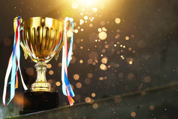 istock Low key golden trophy on the blur gray background with abstract shiny lights . 841764730