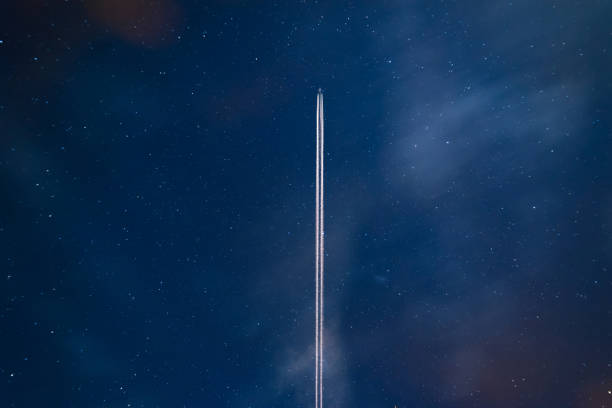airplane contrail against clear blue sky - rasto de fumo de avião imagens e fotografias de stock