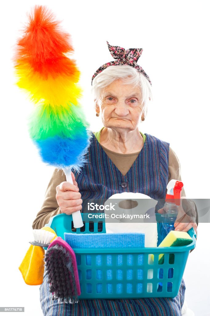 Happy senior housekeeper Portrait of a happy senior lady doing housework holding cleaning equipment Cleaning Stock Photo