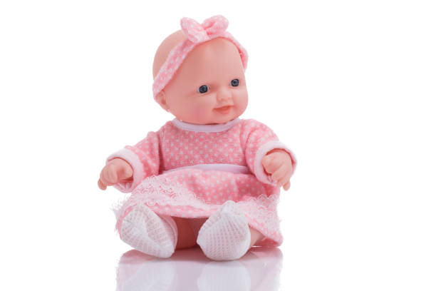 Cute little plastic baby doll isolated on white background Cute little plastic baby doll with blue eyes sitting on empty background figurine photos stock pictures, royalty-free photos & images