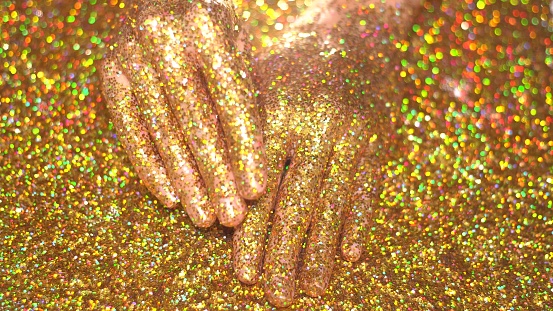 Woman's hand in golden glitter. Glamour concept