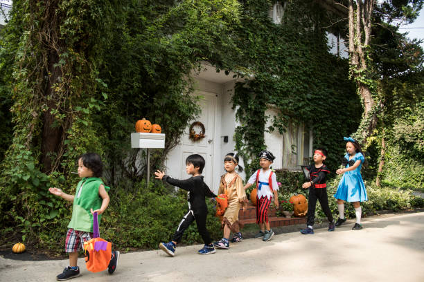 bambini che marciano davanti alla casa indossando costumi. - indian costume foto e immagini stock