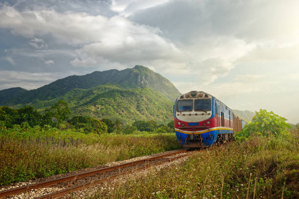 Train passing at sunset against the background of mountains stock photo