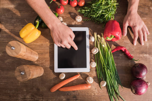 istock top view of young man cooking with tablet and pointing at blank screen 841800120