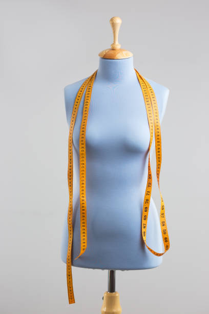 istock Blue tailor dummy with measuring tape alongside the wall. 841806914