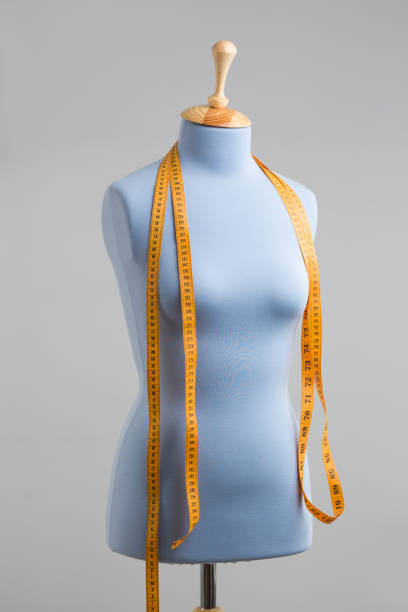 istock Blue tailor dummy with measuring tape alongside the wall. 841806972
