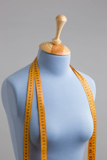 istock Blue tailor dummy with measuring tape alongside the wall. 841807052