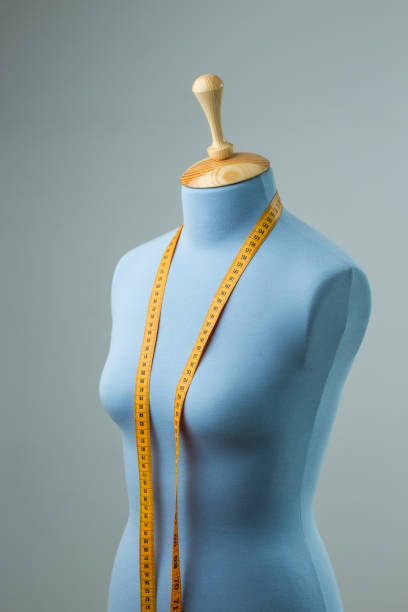 istock Blue tailor dummy with measuring tape alongside the wall. 841807440