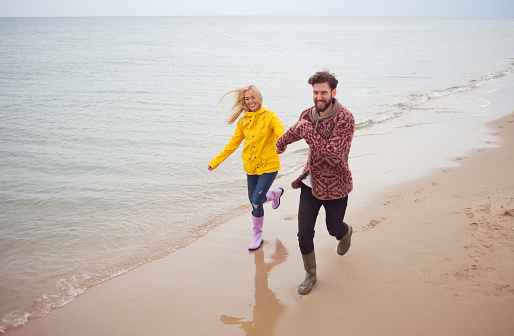 Beautiful couple enjoying at their winter vacation on beach