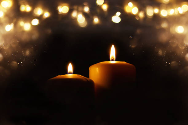 istock Burning candles over black background with bokeh glitter lights 841813646