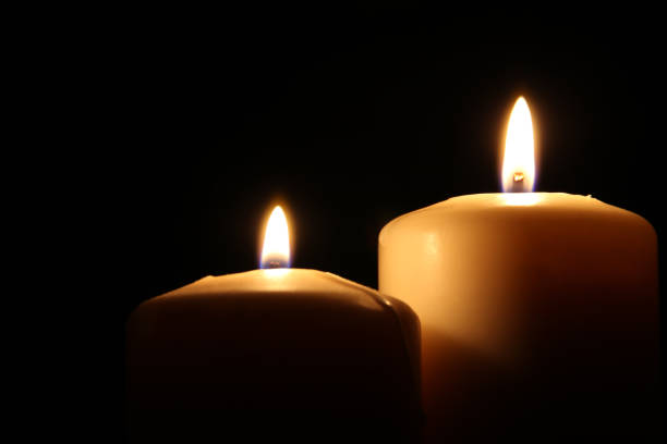 istock Burning candles over black background with bokeh lights 841814310
