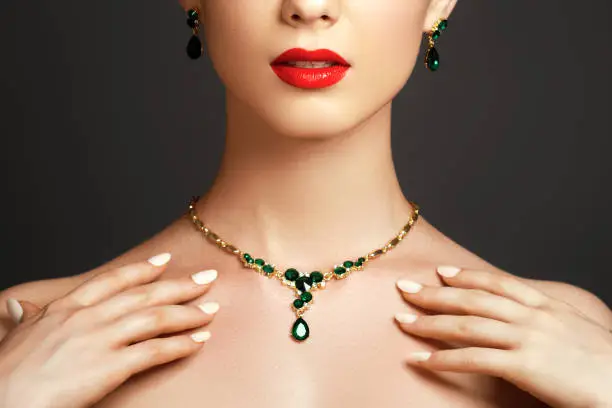Elegant fashionable woman with jewelry. Beautiful woman with emerald necklace. Young beauty model with emerald pendant. Jewellery and accessories. Fashion and beauty salon. Perfect lip makeup
