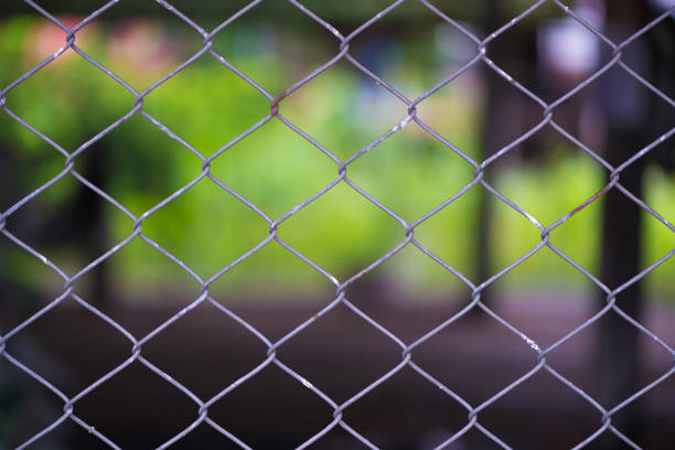 istock Rusty Chain Link Fence of steel netting on blur background. 841829586