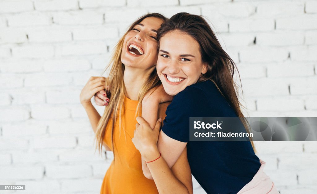 Friends dancing indoors Two friends dancing and having fun in front of a white brick wall. Friendship Stock Photo