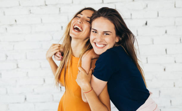 Friends dancing indoors Two friends dancing and having fun in front of a white brick wall. toothy smile photos stock pictures, royalty-free photos & images