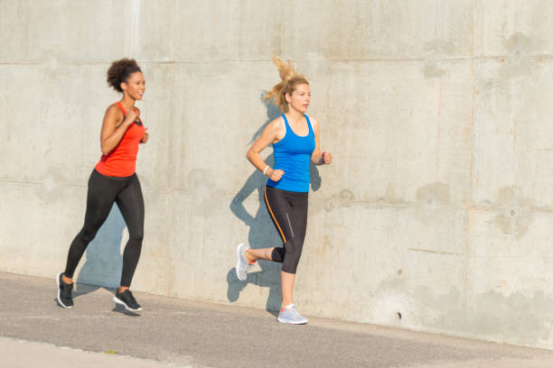 istock Two female athletes running together 841840780