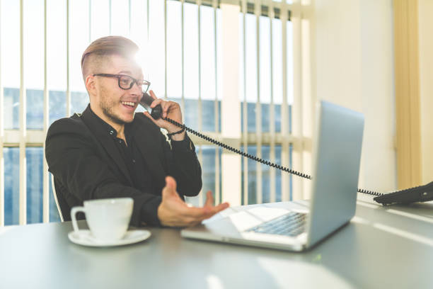 istock Attractive young businessman talking on the phone in office 841846526