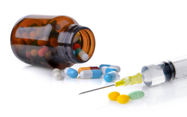 istock pills and syringe with liquid isolated on white background 841846918