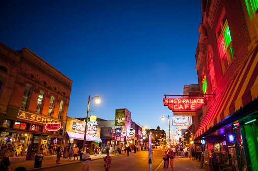 Memphis, TN, USA - June 25, 2017: View of a crowd of tourists enjoying the music clubs and retail establishments that line the famous music district of Beale Street in downtown Memphis, TN at dusk.  Beale Street is on the U.S. National Register of Historic Places.